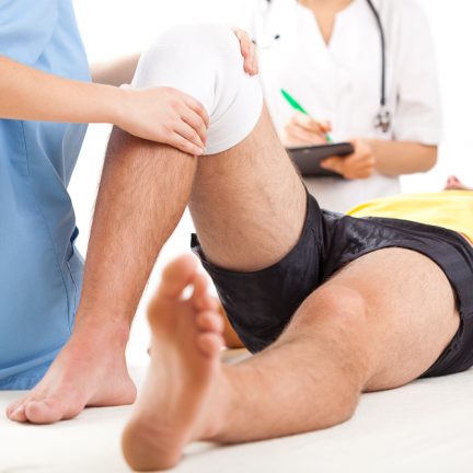 Qualified medical team examining knee condition in clinic for athletes.